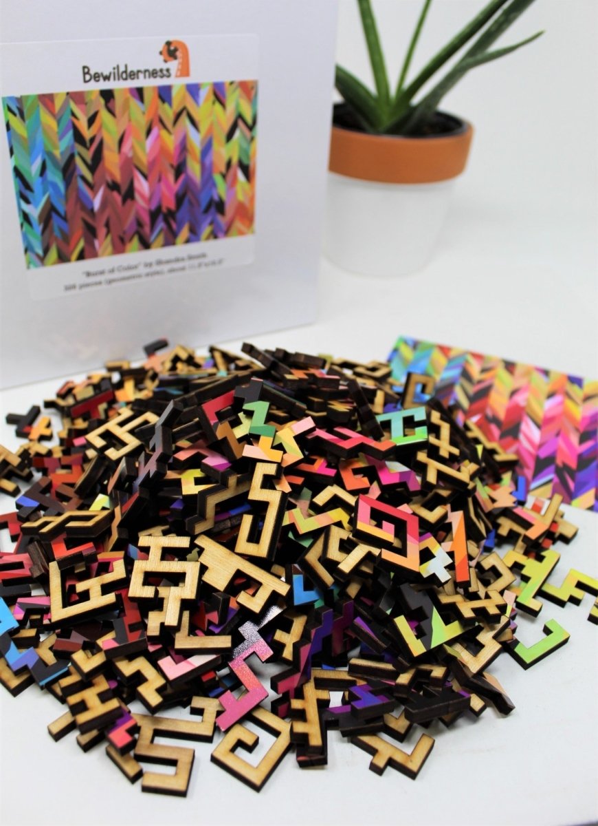 Burst of Color by Shandra Smith, abstract art geometric wooden puzzle by Bewilderness, pile of pieces with box in background